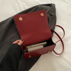 Retro deep red leather crossbody bag showing internal space for a phone and wallet