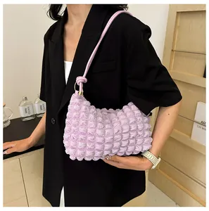 Close-up of light purple popcorn texture fabric on a French style ruched shoulder bag