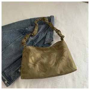 Détail du sac plissé olive foncé avec un motif de marbre artistique sur le tissu