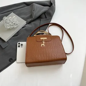 Sac à main marron effet crocodile avec poignée dorée et pendentif cerf élégant