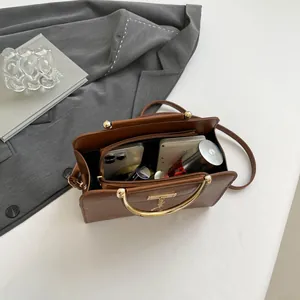 Sac à main marron motif crocodile avec poignées dorées et compartiments spacieux