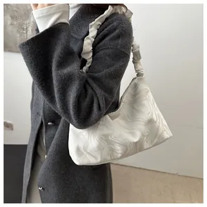 Détail de la bandoulière froncée et du motif marbré sur un sac cabas en similicuir