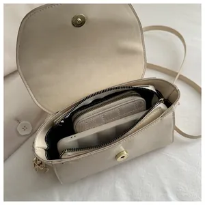 Top view showing the spacious interior compartment of the beige saddle bag with magnetic closure