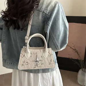 Straw woven handbag with floral embroidery and star detail on blue jacket model