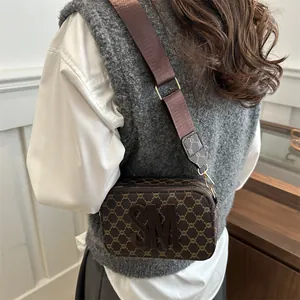 Minimalist square crossbody camera bag with brown monogram pattern and 3D letters