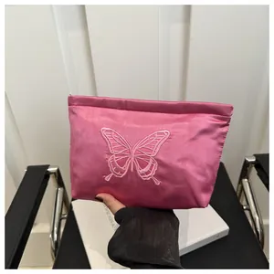 Pink satin cosmetic bag with detailed butterfly embroidery and smooth silk texture