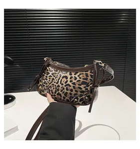 Detail of leopard print shoulder bag featuring side leather bow and gold hardware