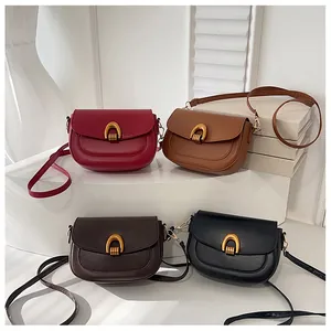 Collection of minimalist leather saddle bags in red, brown, and black with golden U-buckles
