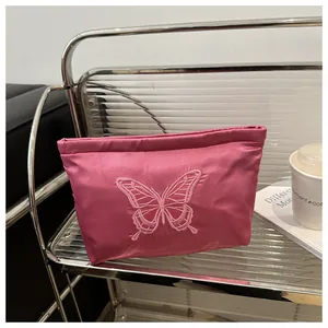Detailed close-up of fuchsia satin bag with exquisite butterfly embroidery and silky texture