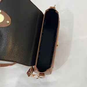 Brown minimalist saddle bag with magnetic closure and spacious interior compartment