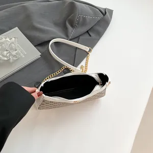 Chic underarm bag with tan monogram print, white leather trim and gold chain strap