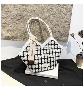 Dettaglio della borsa tote in tweed a scacchi con apertura a V e tracolla in pelle bianca