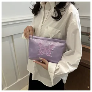 Close-up of lavender satin storage bag featuring detailed butterfly embroidery on the front