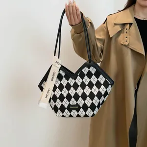 Dettaglio della borsa tote a scacchi bianchi e neri con etichetta in pelle Fashion & Bags