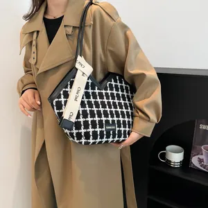 Dettaglio della borsa tote in tweed a scacchi bianca e nera con tracolla in tela