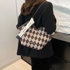 Dettaglio del motivo geometrico a rombi e della patch logo sulla grande borsa tote
