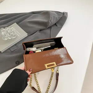 Brown patent leather square bag with gold chain strap and spacious interior