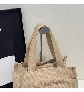 Détail du sac cabas en velours côtelé beige avec poignées renforcées et zip métallique