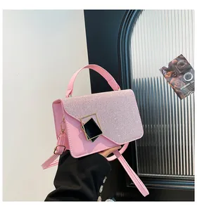 Close-up of pink woven handbag featuring shimmering sequins and a gold geometric buckle