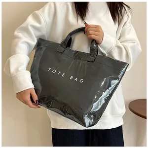 Dettaglio borsa shopper nera trapuntata con stampa bianca su materiale lucido impermeabile