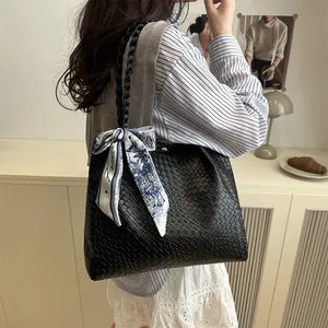 Large black woven tote bag with a decorative floral silk scarf and metal magnetic closure