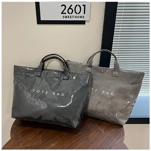 Dettaglio di borse tote lucide impermeabili in grigio scuro e talpa stile moderno