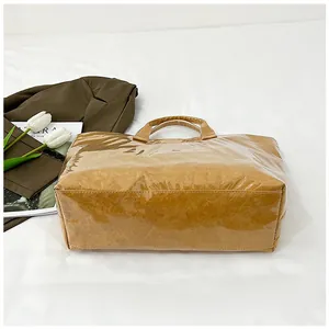 Détail d'un grand cabas en papier marron avec couche de revêtement PVC transparent