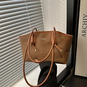 Brown woven tote bag with FASHION logo and leather handles for casual commute