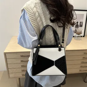 Modern geometric patchwork handbag in black and white with faux crocodile texture