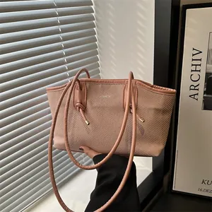 Modern nude pink woven tote bag with fashion logo and unique knotted handles