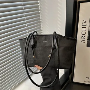 Black woven tote bag with silver FASHION print shown in natural window light