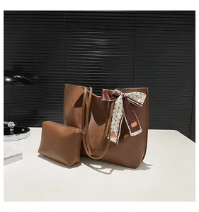 Detail view of brown leather tote bag with matching inner pouch and silk scarf decor