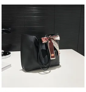 Large black tote bag in smooth PU leather with a decorative printed silk scarf on the handle