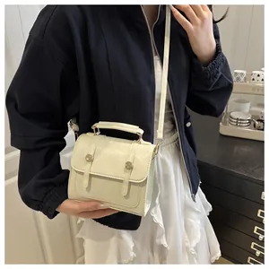 Detail showing off-white crossbody bag with gold hardware and removable shoulder strap