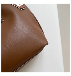 Detail of dark brown tote bag with pebble texture and decorative silk scarf accessory