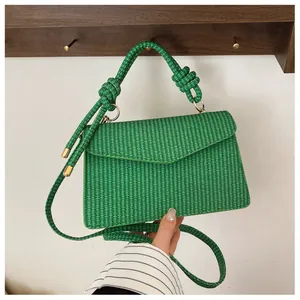 Détail du sac à main carré tressé vert avec poignée en corde nouée et boucle métallique