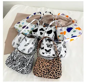 Flat lay of multiple leopard and animal print shoulder bags in various stylish patterns