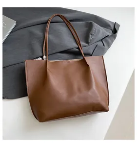 Detail shot of brown faux leather tote bag with fine matte texture and stitching
