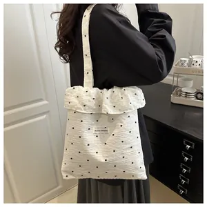 Détail du sac cabas en mousseline fleurie avec bord volanté et étiquette AGOGO