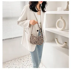 Detail view of leopard print shoulder bag in a minimalist interior with shadow patterns