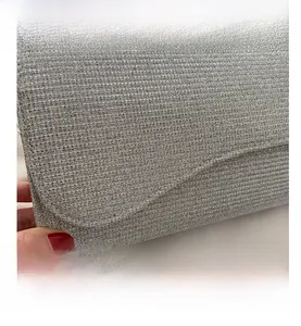 Macro shot of silver glitter texture and horizontal grain on a stylish clutch bag