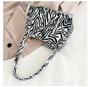 Detailed macro view of zebra pattern handbag with metallic gold zipper and textured fabric