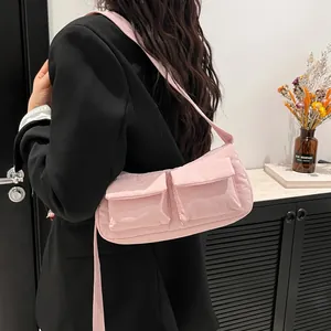 Pink quilted nylon shoulder bag with dual front pockets shown on model with black blazer