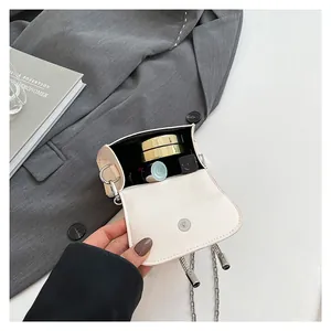 Beige mini flap bag with bow detail, interior view with lipstick and compact powder
