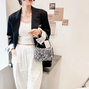Fashionable zebra print shoulder bag for women styled with a casual black blazer outfit