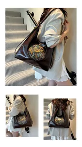Detail of dark brown leather backpack with colorful ethnic embossed relief and gold hardware