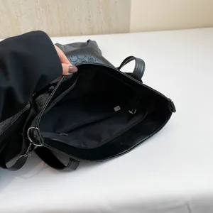 Black tote bag with skull embossing, spacious interior, and silver metal hardware