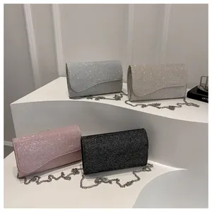 Detailed view of four glitter clutch bags in silver, gold, pink, and black with chain straps