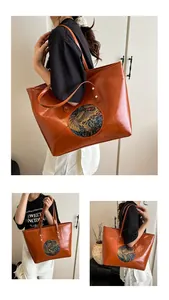 Detail of caramel faux leather tote bag with ethnic elephant embroidery and studs