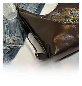 Detail of deep brown faux leather tote bag with vintage embossed colorful side panel